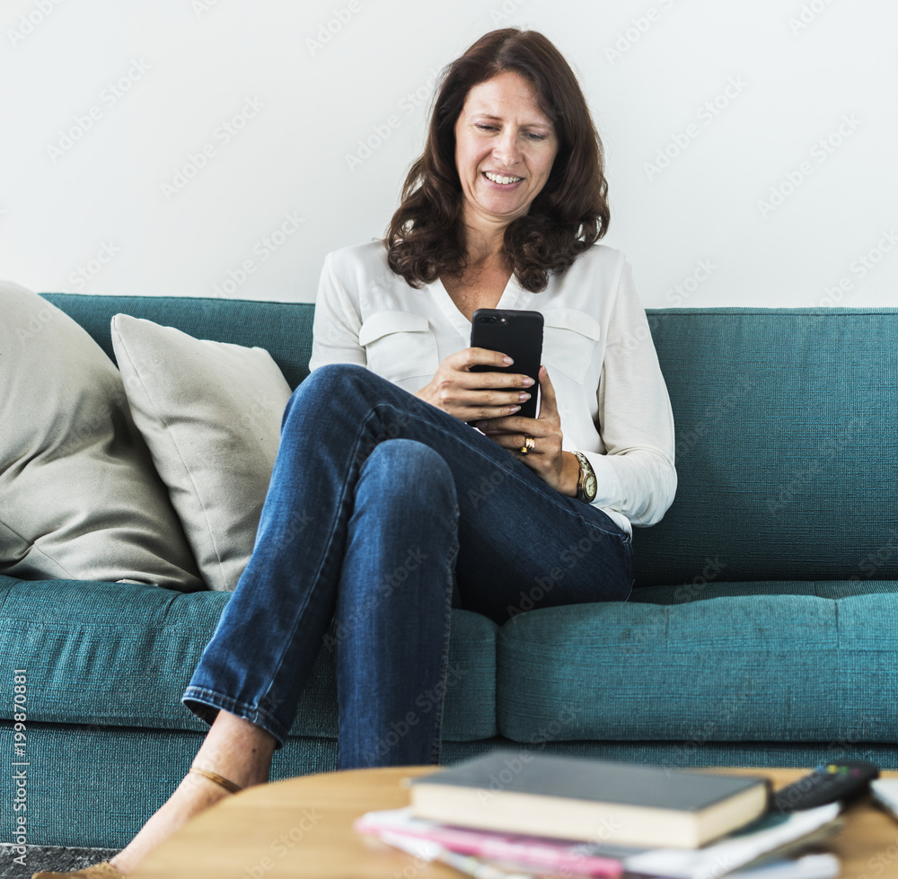 Woman using mobile phone on the sofa Woman using mobile phone on the sofa