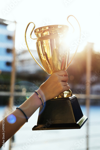 Feminine hand holding a trophy outdoors photo