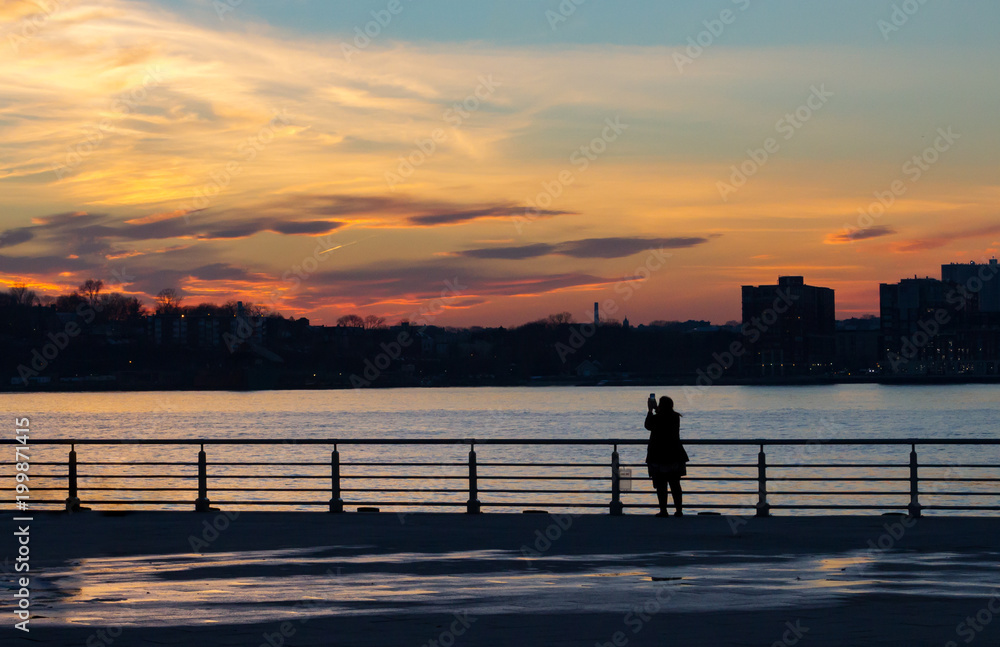 Silhouette of women photographing the sunset in New York City