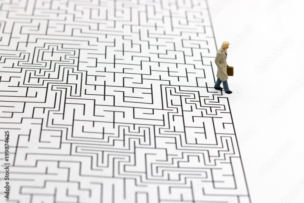 Miniature people: Businessman standing on finish of maze. Concepts of finding a solution, problem solving and challenge. Miniature people: Businessman standing on finish of maze. Concepts of finding a solution, problem solving and challenge.