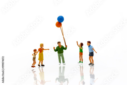Miniature people children holding balloon  with sunlight, happy family day concept.