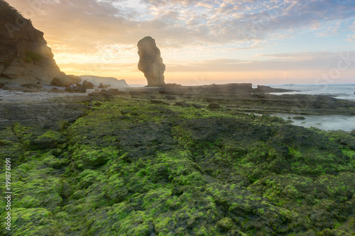 Amazing sunrise at Lombok beach with huge rock formation.
