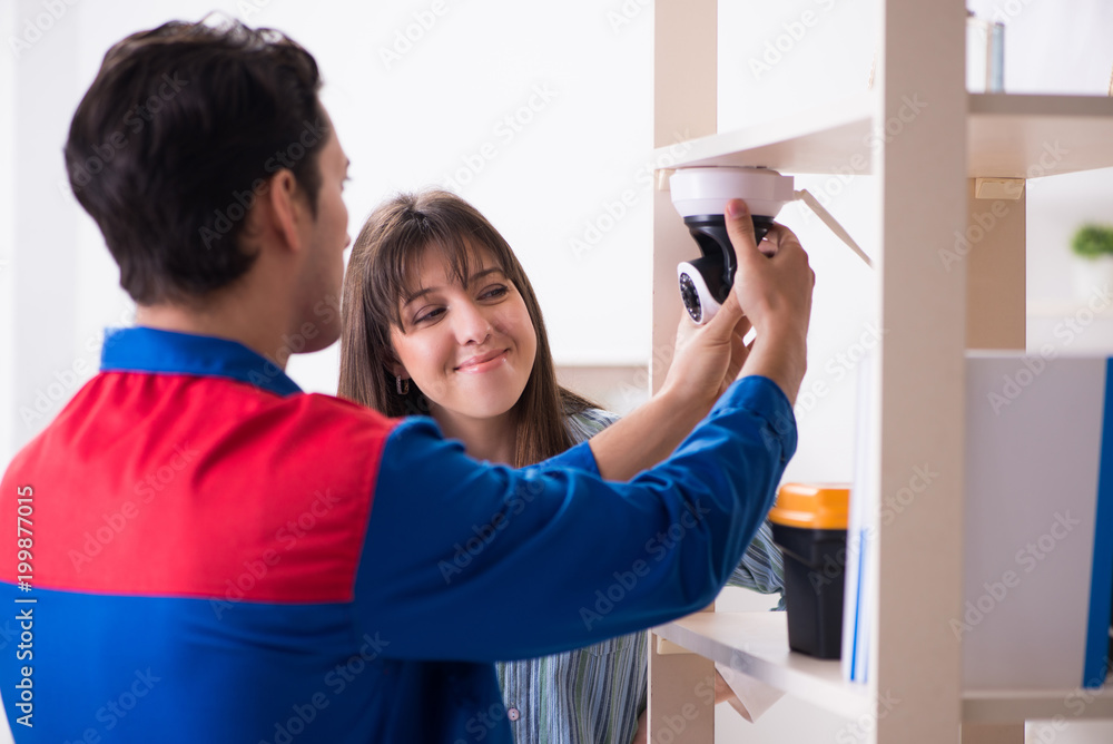 Client getting securty camera installed at home by contractor