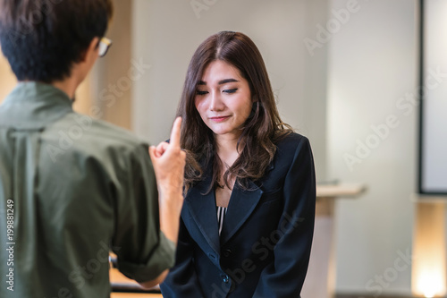 Canvas Print Reaw view of Furious boss scolding asian young businesswoman in formal suit by p