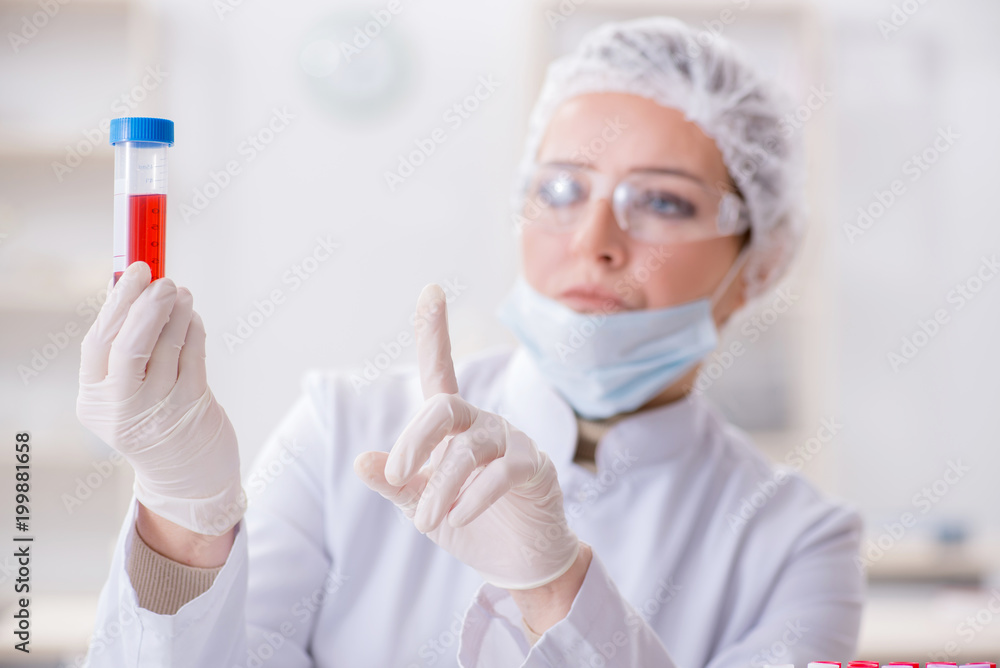 Woman doctor checking blood samples in lab Woman doctor checking blood samples in lab