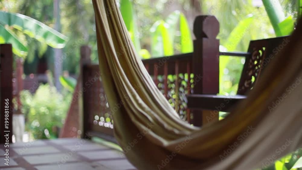 Hammock on the terrace of a villa in the jungle on blurred bokeh from plant. 1920x1080