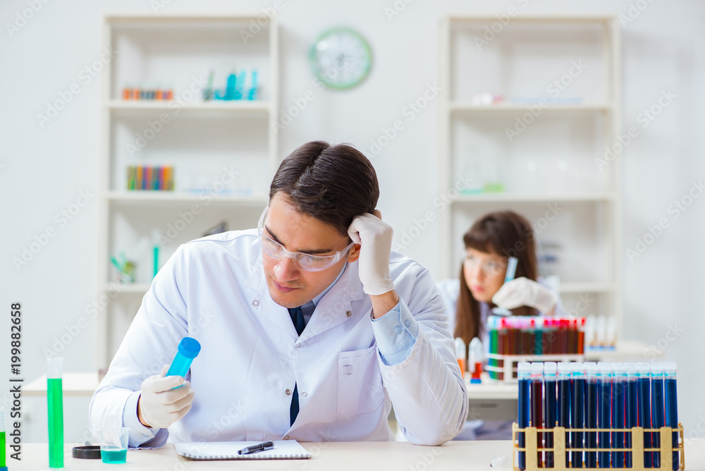 Two chemists working in lab experimenting - obrazy, fototapety, plakaty 