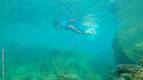 Slowmotion shot of a young man snorkeling and diving dip into sea photo
