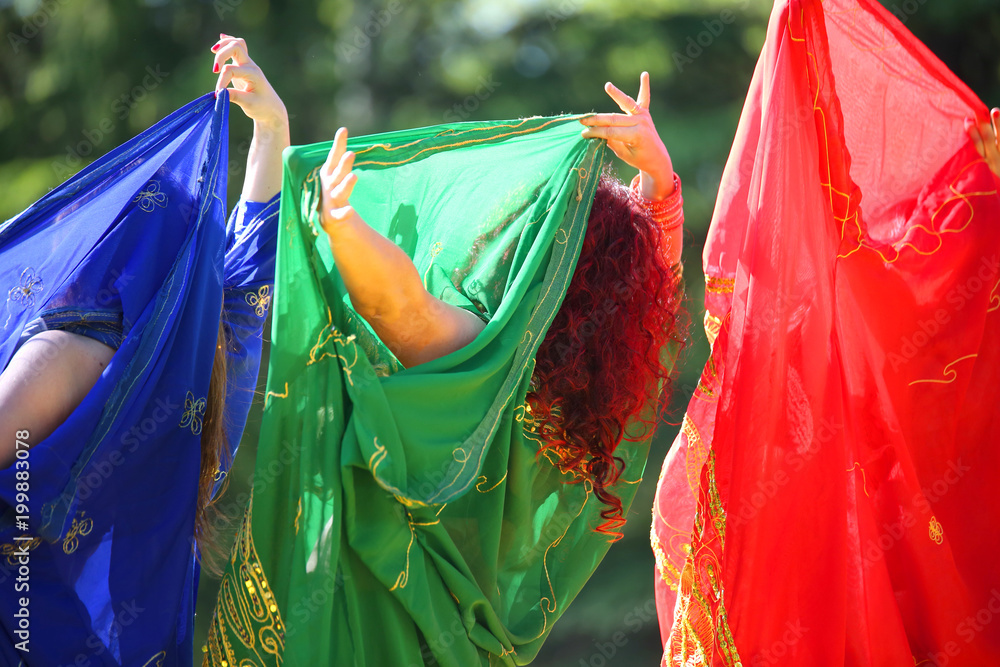 women with colorful clothes during belly dancing