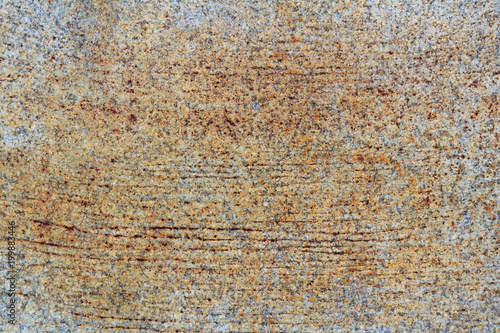 Granite slab with scratches and brown stains. Natural stone texture