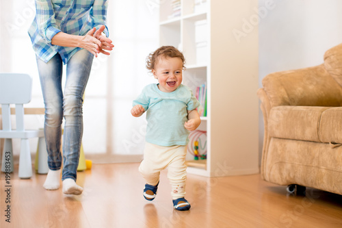 Quadro su tela Baby toddler have a fun running in living room with his mother