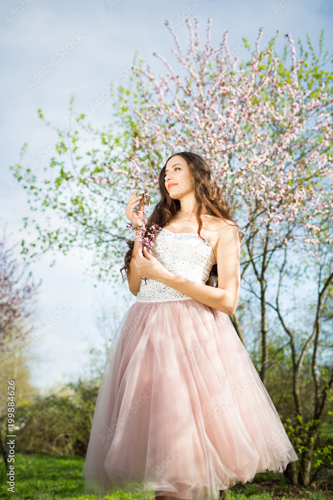 Young woman in the garden blooming in spring