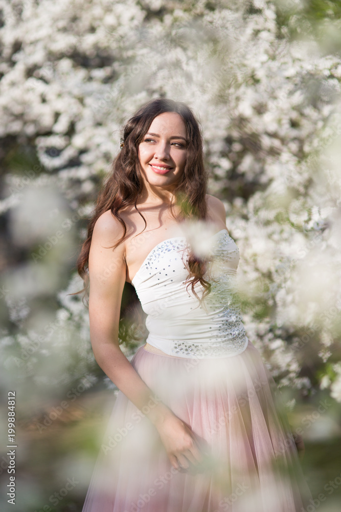 Young woman in the garden blooming in spring Young woman in the garden blooming in spring