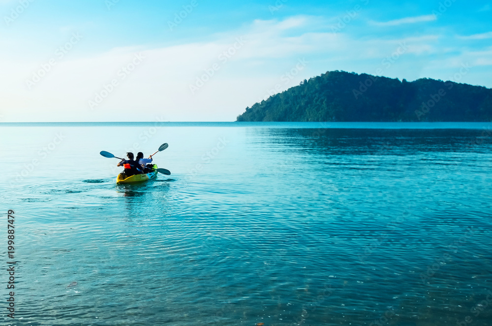 Kayak at dawn in the calm sea. Tourists go kayaking off the coast of Koh Chang, Thailand