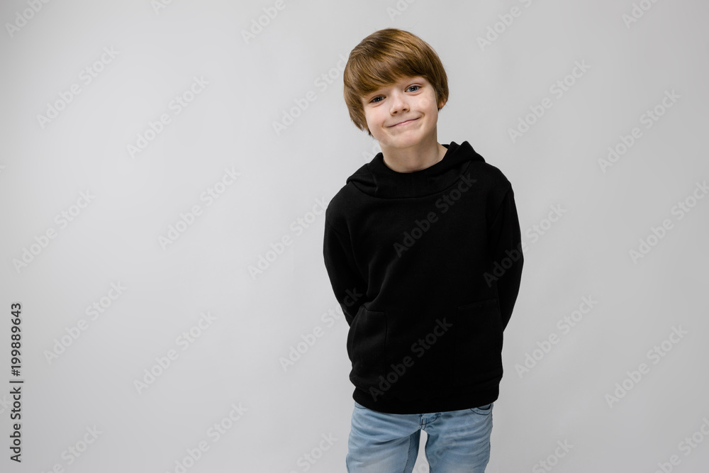 Portrait of adorable smilling little boy standing in studio on grey background Portrait of adorable smilling little boy standing in studio on grey background