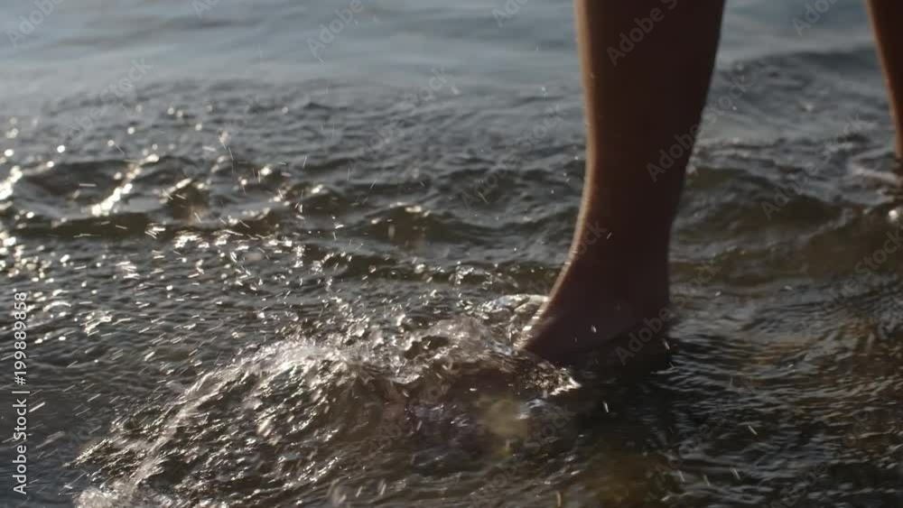 Low-section shot of legs of unrecognizable woman walking and running through water on summer day Low-section shot of legs of unrecognizable woman walking and running through water on summer day