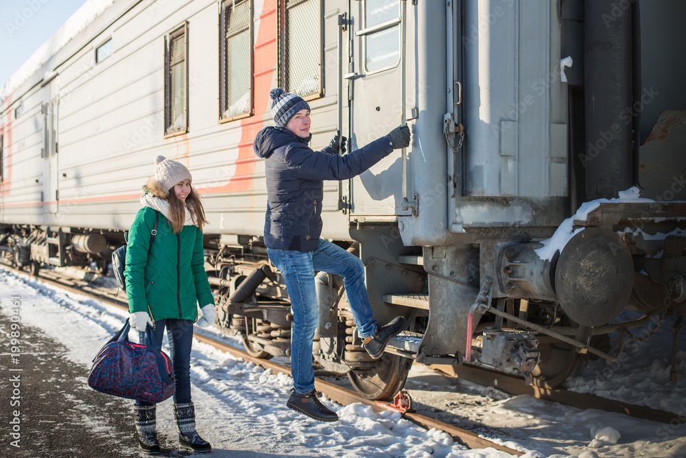 Couple at railway station near train in a winter time Couple at railway station near train in a winter time