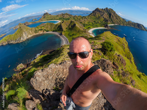 Caucasian man makes selfie at Padar Island in Flores, Indonesia. photo