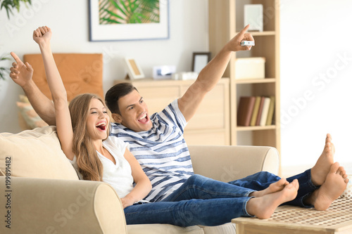 Young couple watching TV on...