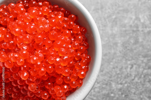Ceramic bowl with delicious red caviar on table, closeup