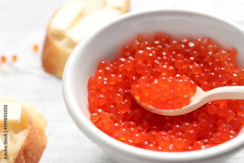 Bowl and spoon with red caviar, closeup Bowl and spoon with red caviar, closeup