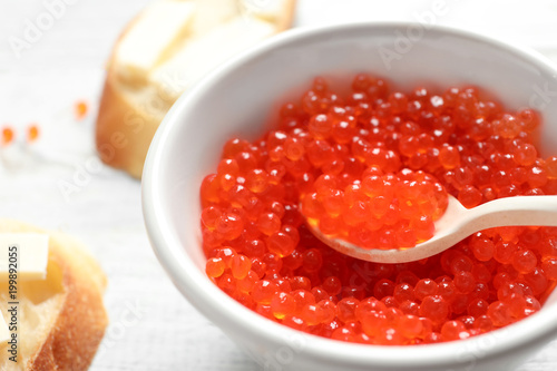 Bowl and spoon with red caviar, closeup