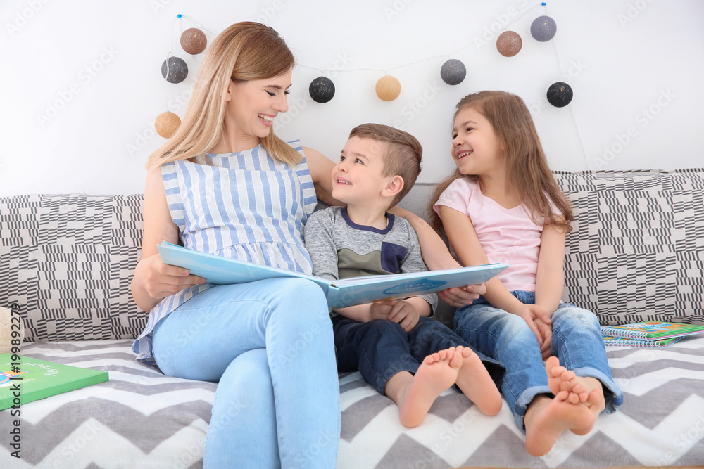 Nanny reading book to little children at home Nanny reading book to little children at home