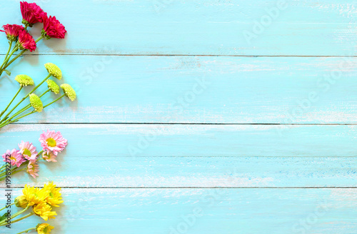Bouquet of colorful chrysanthemum flowers on blue wooden background.  Concept flowers of spring, top view and border design,