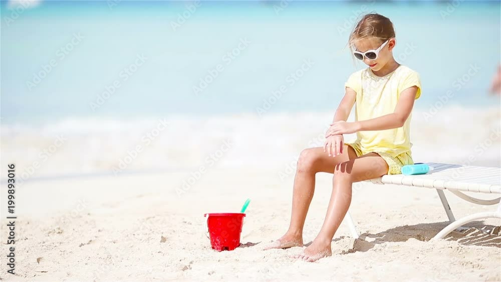 Little adorable girl with sunscreen is protected from the sun Little adorable girl with sunscreen is protected from the sun