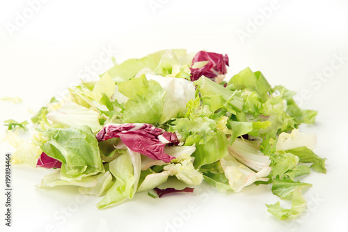 Close-up of a salad mix of fresh green leaves frieze, radicchio, endive. Dietary vegetable menu.
