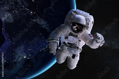 Fototapeta Naklejka Na Ścianę i Meble -  Astronaut in outer space on background of the night Earth. Elements of this image furnished by NASA.