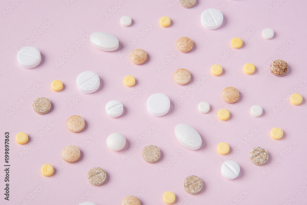 Different tablets and pills in the package and without it on a pink background Different tablets and pills in the package and without it on a pink background