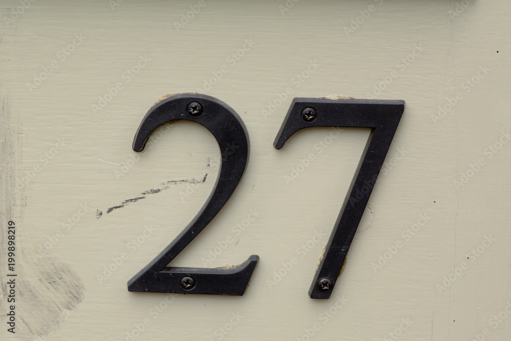 Naklejka premium House number 27 sign on wooden door