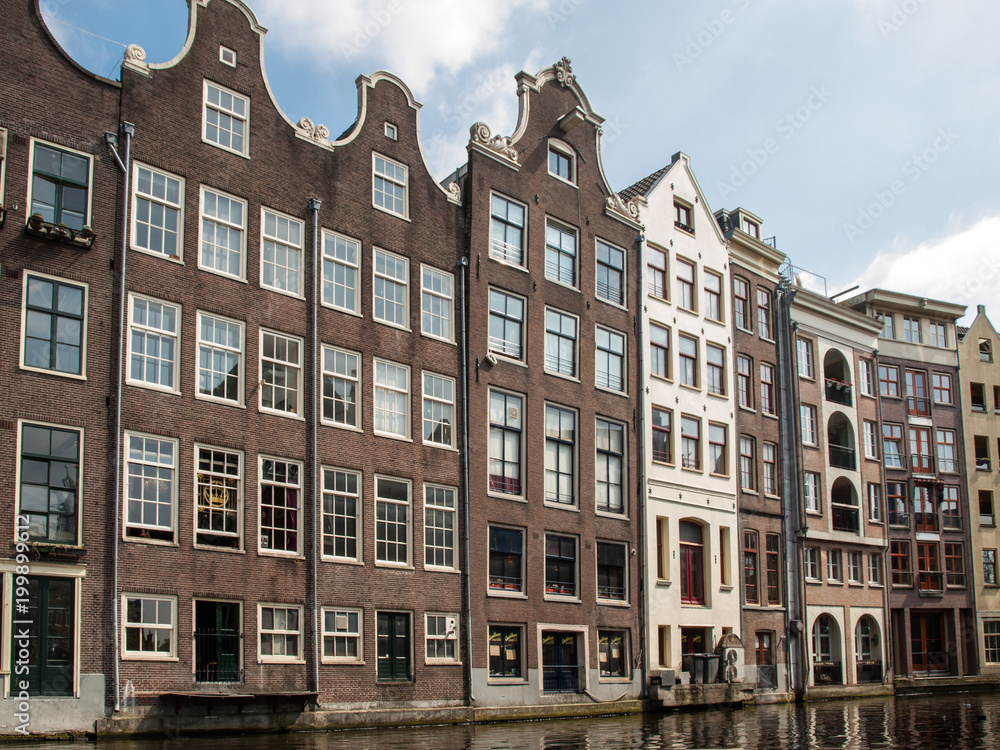 Typical gabled houses on Damrak street in Amsterdam, Holland, Netherlands Typical gabled houses on Damrak street in Amsterdam, Holland, Netherlands