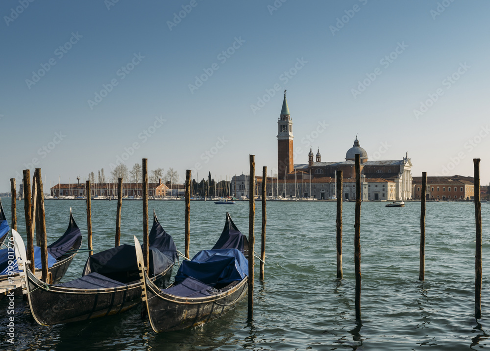 Gondolas moored by Saint Mark square with San Giorgio di Maggiore church in Venice, Italy with copy space