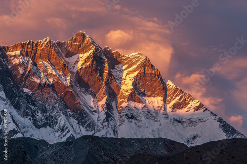 Beautiful sunset with pinkish clouds over Himalayan mountains. Lhotse mountain south face view from Everest Base Camp Trek. Himalaya mountains landscape, Sagarmatha National Park, Nepal. photo