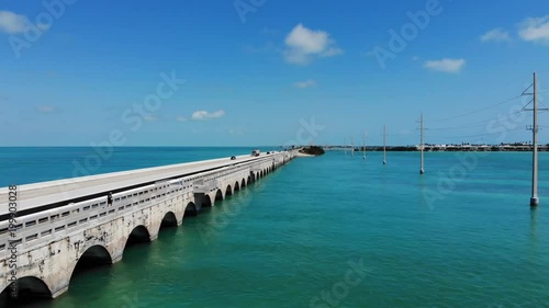Wallpaper Mural Aerial view of a highway and bridge connecting the Florida Keys. Fisherman and traffic on the bridge. Sunny day with warm blue water. The clip focuses on the side view of the bridge.  Torontodigital.ca