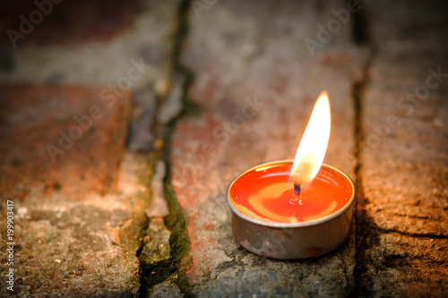 Prayer and hope concept.Candle flame light at night with abstract circular bokeh background photo