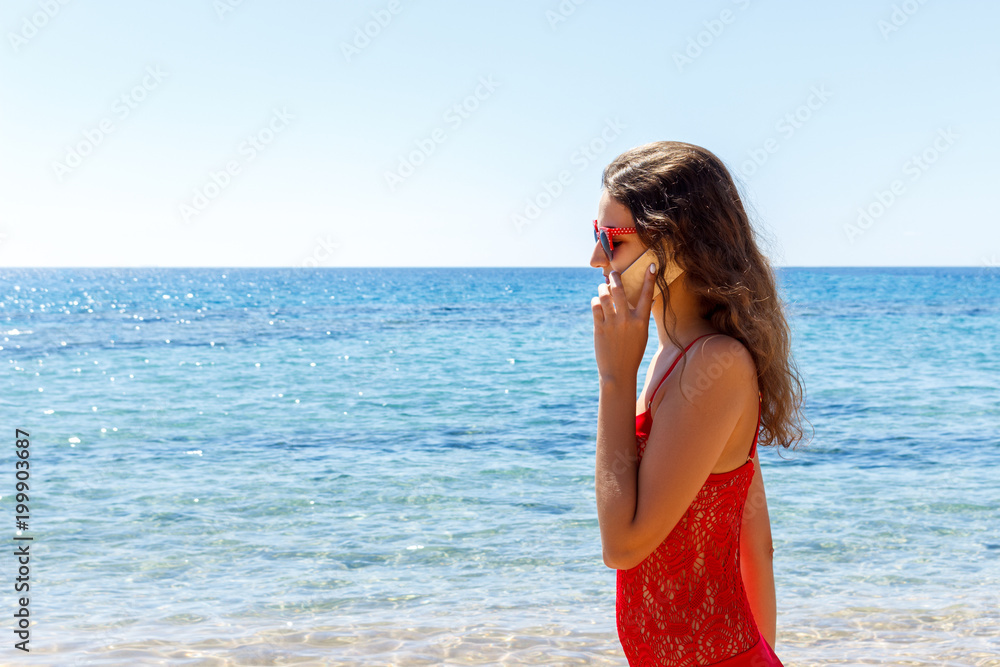 young smiling woman talking by phone on a beach young smiling woman talking by phone on a beach