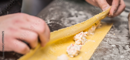 Tableau sur toile Chef's hands prepares Italian food stuffed pasta ravioli