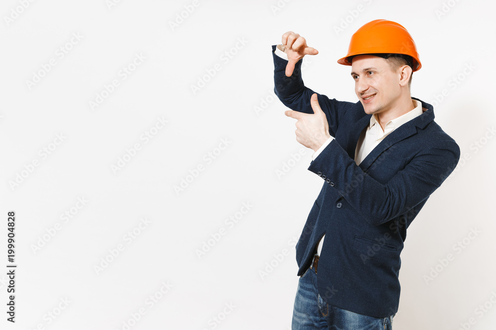 Young handsome smiling businessman in dark suit, protective construction orange helmet making hands photo frame gesture isolated on white background. Male worker for advertisement. Business concept. Young handsome smiling businessman in dark suit, protective construction orange helmet making hands photo frame gesture isolated on white background. Male worker for advertisement. Business concept.