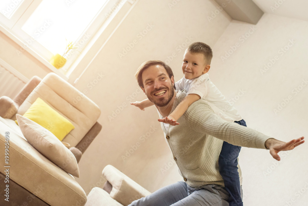 Obraz premium Father and son playing together and having fun in living room