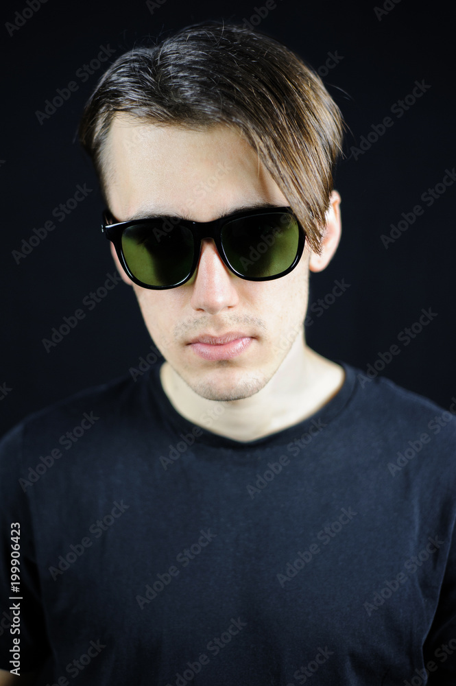 portrait of a young guy on a black background portrait of a young guy on a black background