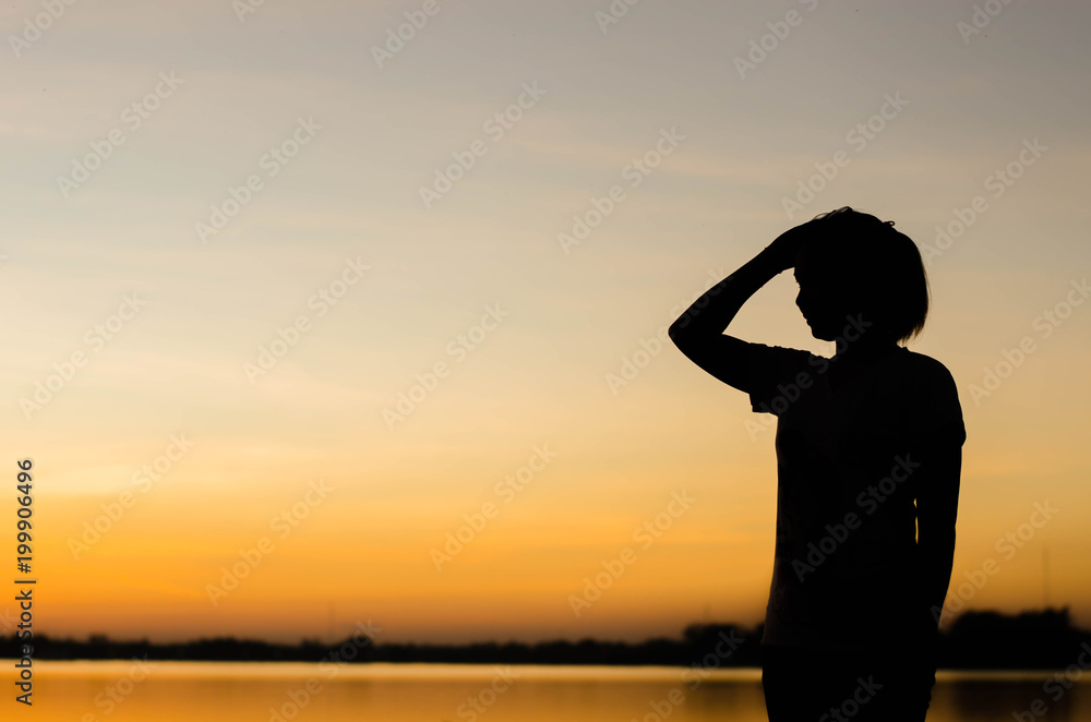 The silhouette of a woman standing looking forward with hope.