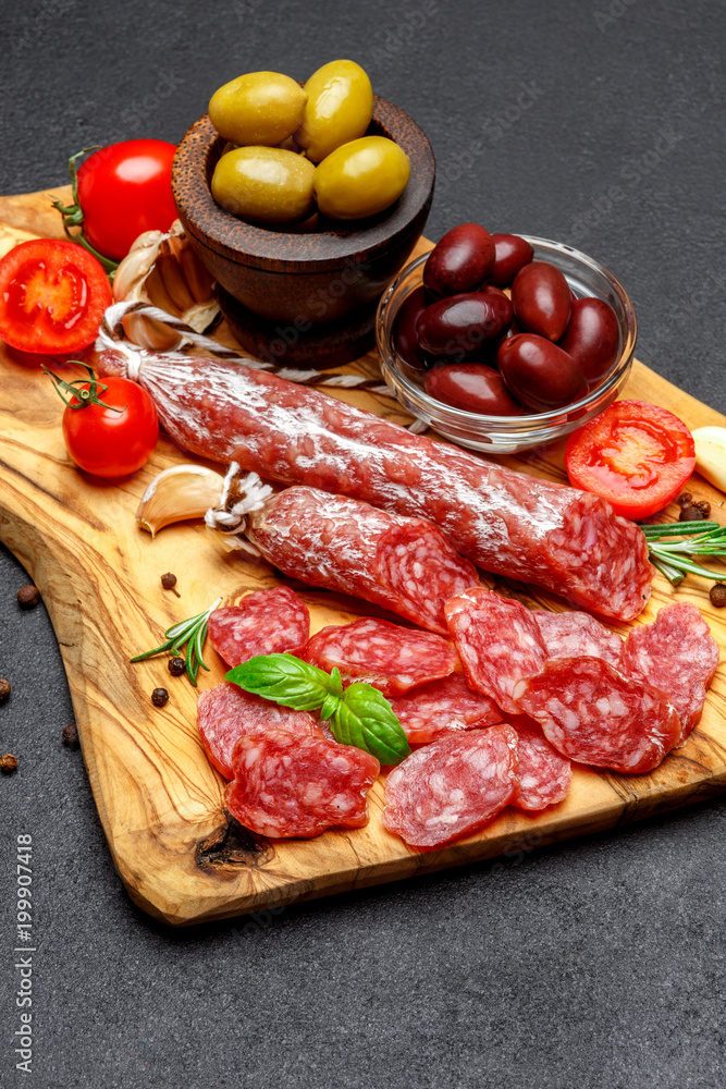 Dried organic salami sausage on wooden cutting board Dried organic salami sausage on wooden cutting board