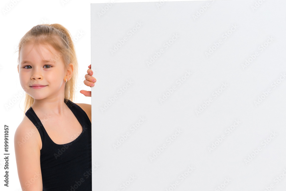 A little girl is looking from behind an empty banner.