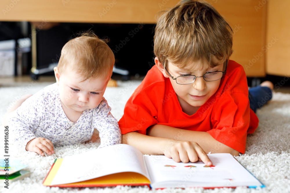 Baby girl and school kid boy reading books at home. Baby girl and school kid boy reading books at home.