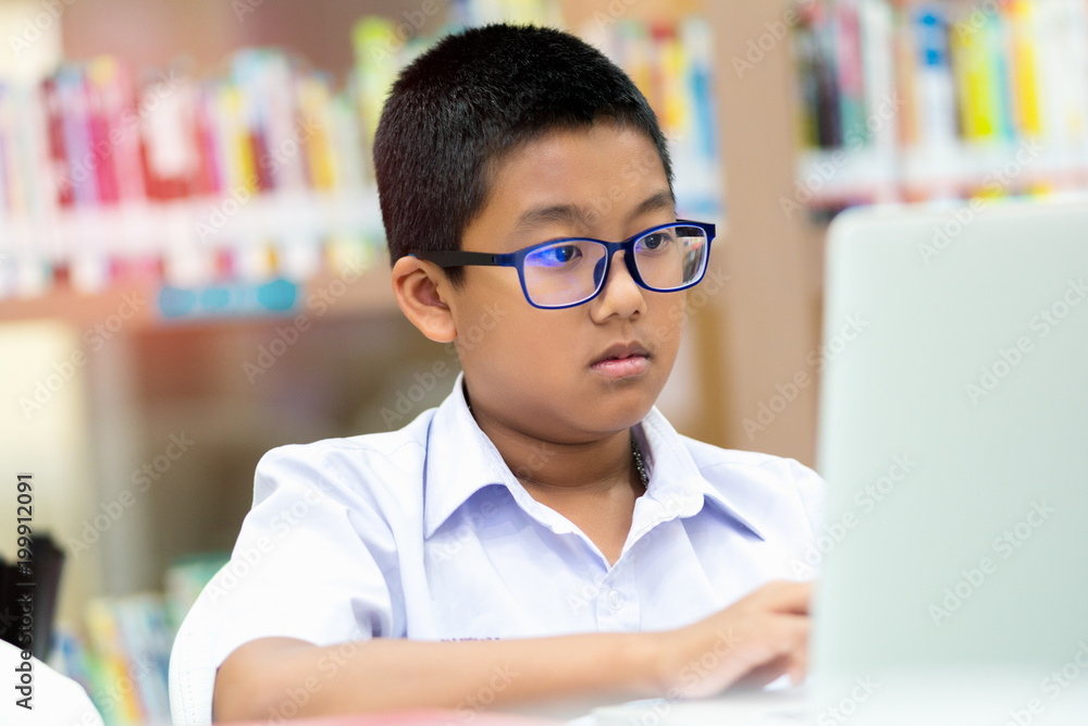 Asian student is searching for knowledge with laptop in the library. Asian student is searching for knowledge with laptop in the library.