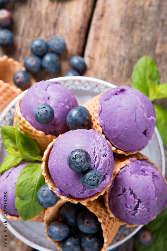 Ice cream, Blueberry ice cream scoop in cone on wooden background. Ice cream, Blueberry ice cream scoop in cone on wooden background.