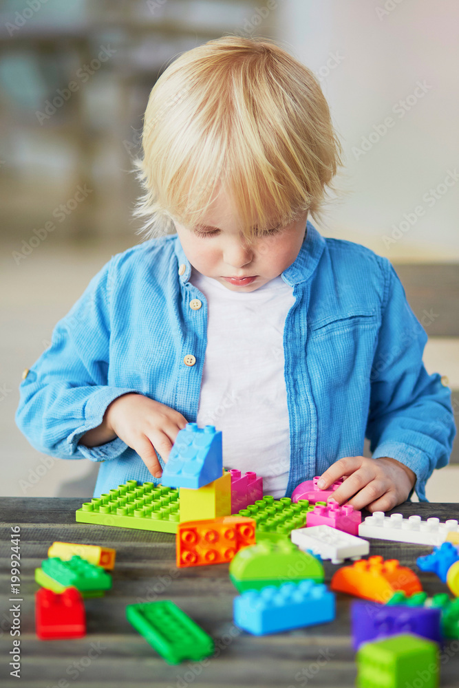 Little boy playing with colorful plastic construction blocks Little boy playing with colorful plastic construction blocks